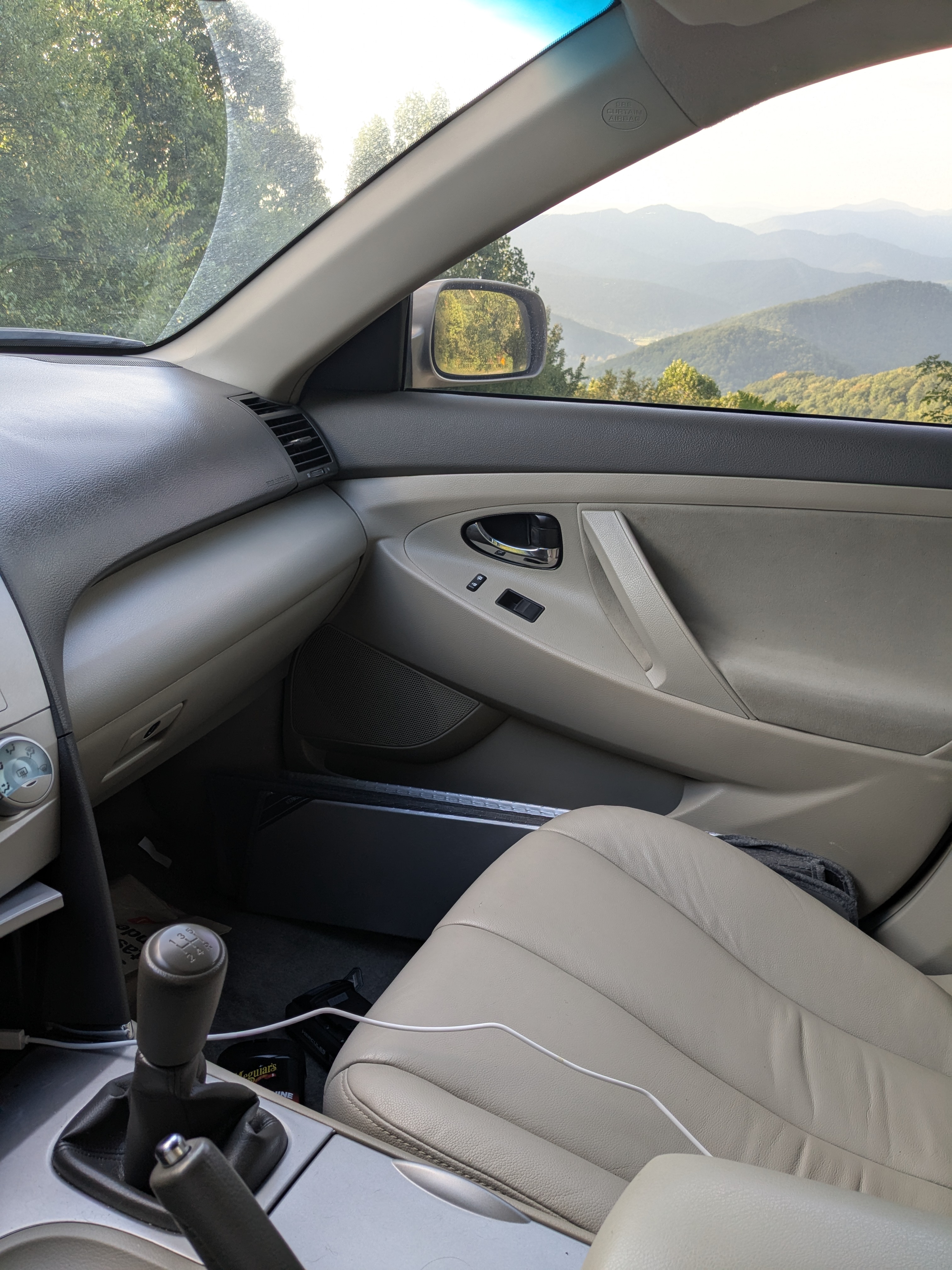 Camry XV40 interior in beige leather with manual shifter, Blue Ridge mountains through the window